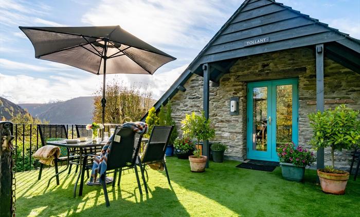Sunny deck with outdoor furniture and plants. Great views of the hills.
